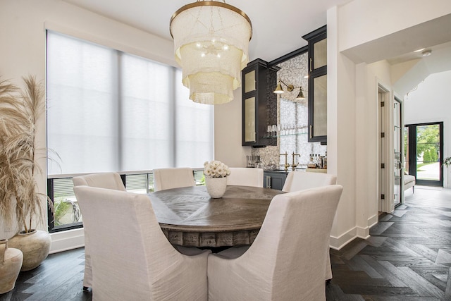 557 Greenwood Ave SE, East Grand Rapids, MI 49506 - dining area with baseboards, bar, and a notable chandelier