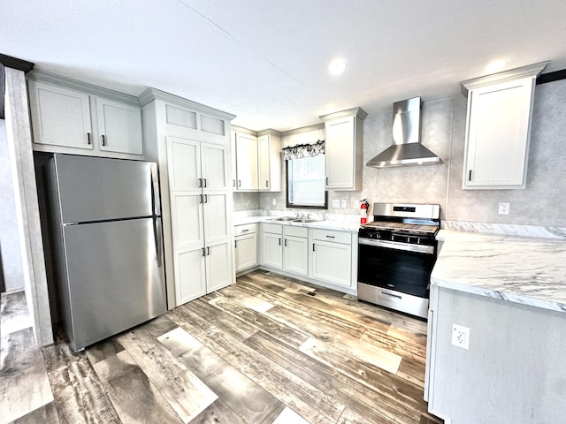 3502 Beech Ln, Twin Lake, MI 49457 - kitchen with appliances with stainless steel finishes, wall chimney exhaust hood, light wood-style flooring, backsplash, and light stone counters