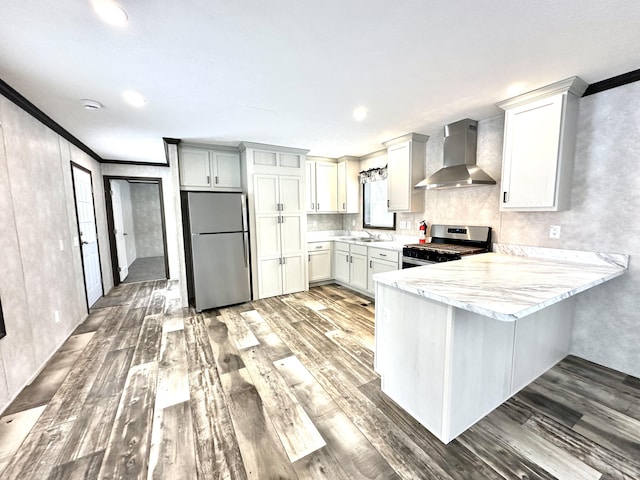 3502 Beech Ln, Twin Lake, MI 49457 - kitchen with stainless steel appliances, wall chimney range hood, ornamental molding, a peninsula, and wood finished floors