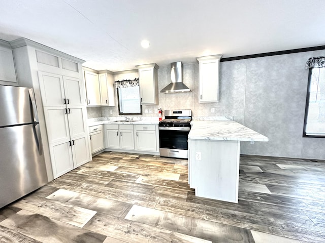 3502 Beech Ln, Twin Lake, MI 49457 - kitchen with stainless steel appliances, wall chimney range hood, light wood-style flooring, a peninsula, and crown molding