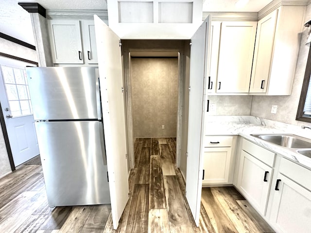 3502 Beech Ln, Twin Lake, MI 49457 - kitchen with freestanding refrigerator, light wood-style floors, light stone counters, and white cabinets