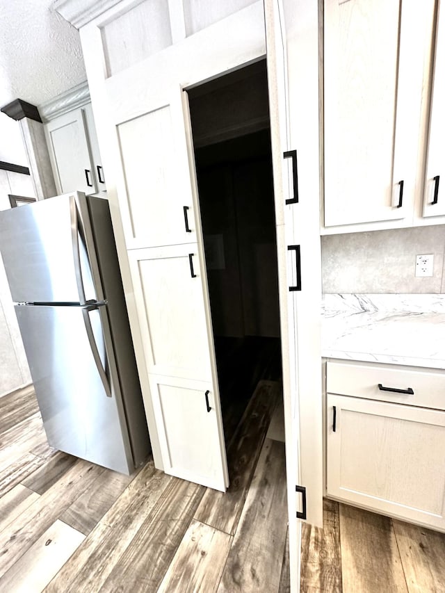 3502 Beech Ln, Twin Lake, MI 49457 - kitchen with freestanding refrigerator, light wood-style floors, and white cabinetry