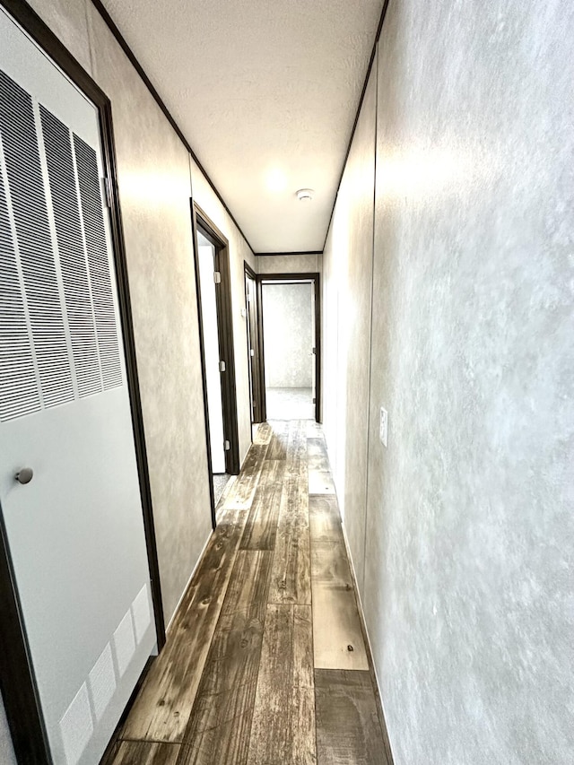 3502 Beech Ln, Twin Lake, MI 49457 - hallway featuring a heating unit, a textured ceiling, wood finished floors, and a textured wall