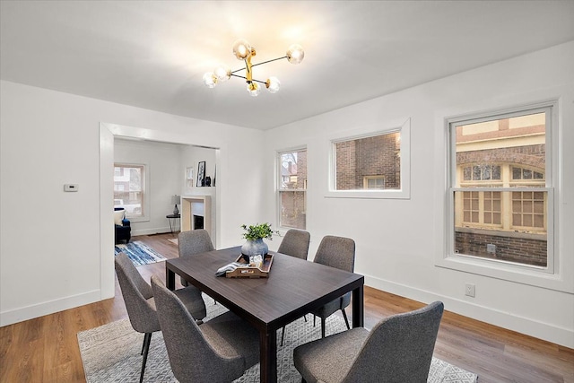 dining area with plenty of natural light, light wood-type flooring, and an inviting chandelier