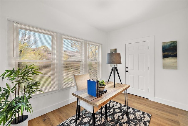 office area featuring baseboards and light wood finished floors