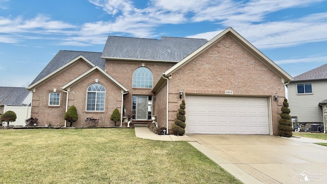 traditional-style house featuring driveway, an attached garage, brick siding, a front lawn, and a shingled roof