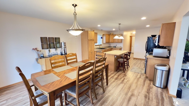 dining room featuring baseboards, recessed lighting, and light wood-style floors