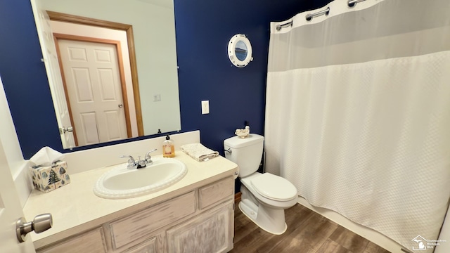 bathroom featuring curtained shower, wood finished floors, toilet, and vanity