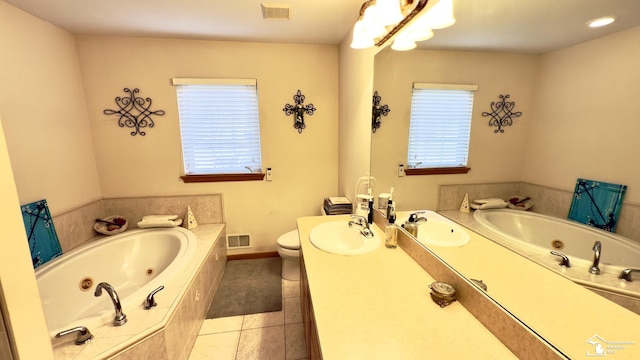 bathroom with a wealth of natural light, visible vents, a tub with jets, and tile patterned flooring
