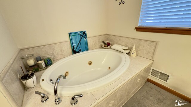 full bathroom featuring baseboards, visible vents, and a tub with jets