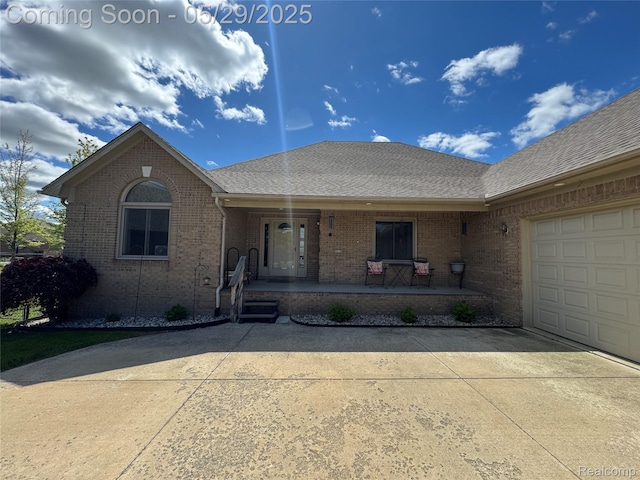 56098 Walker Ct, Macomb, MI 48042 - view of front facade with concrete driveway, brick siding, a porch, a shingled roof, and a garage