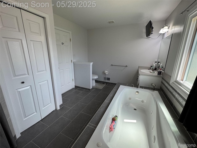 56098 Walker Ct, Macomb, MI 48042 - bathroom with a tub with jets, tile patterned flooring, toilet, vanity, and a closet