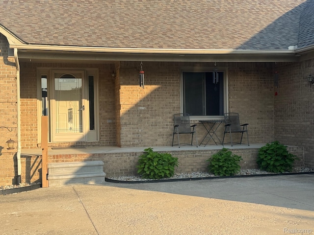 56098 Walker Ct, Macomb, MI 48042 - entrance to property featuring a shingled roof, a porch, and brick siding