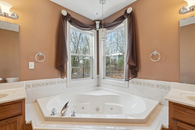 bathroom featuring a tub with jets and vanity
