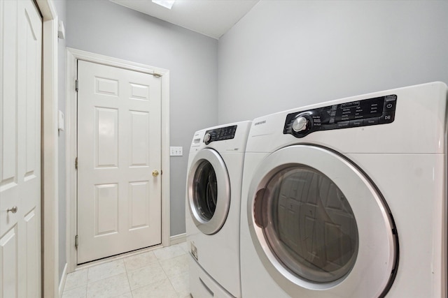 washroom featuring washing machine and clothes dryer, laundry area, and light tile patterned floors
