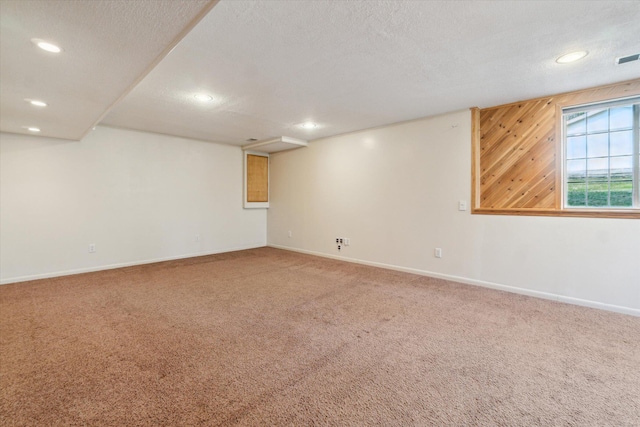 basement featuring baseboards, recessed lighting, carpet, and a textured ceiling