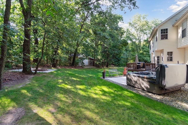 view of yard featuring an outdoor structure, a jacuzzi, and a deck