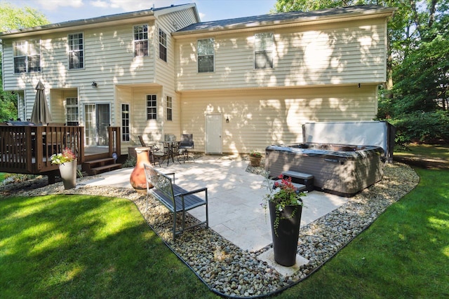 rear view of house with a lawn, a deck, a hot tub, and a patio area