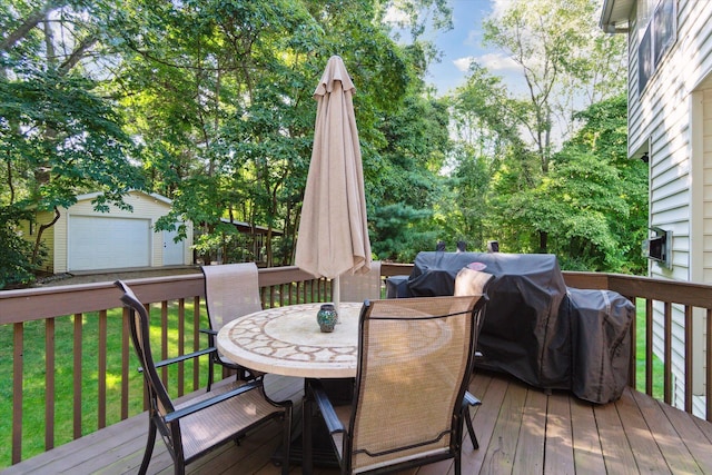 deck with an outdoor structure, outdoor dining area, a garage, and a lawn