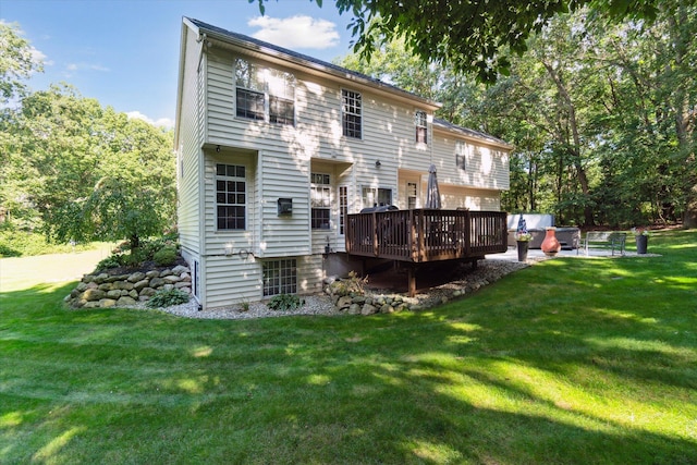 rear view of property featuring a lawn and a deck