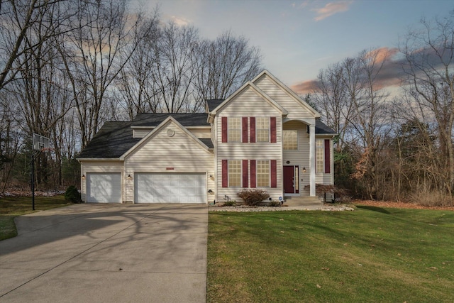 view of front of home with a front yard, concrete driveway, and an attached garage