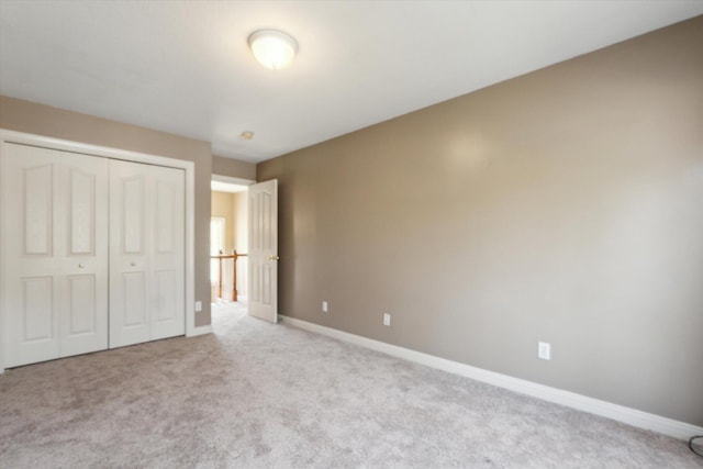 unfurnished bedroom featuring a closet, carpet, and baseboards