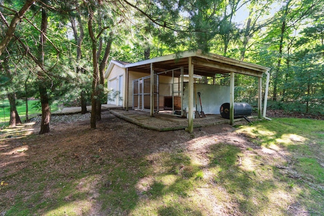 view of yard featuring a pole building, heating fuel, a garage, an outdoor structure, and a carport