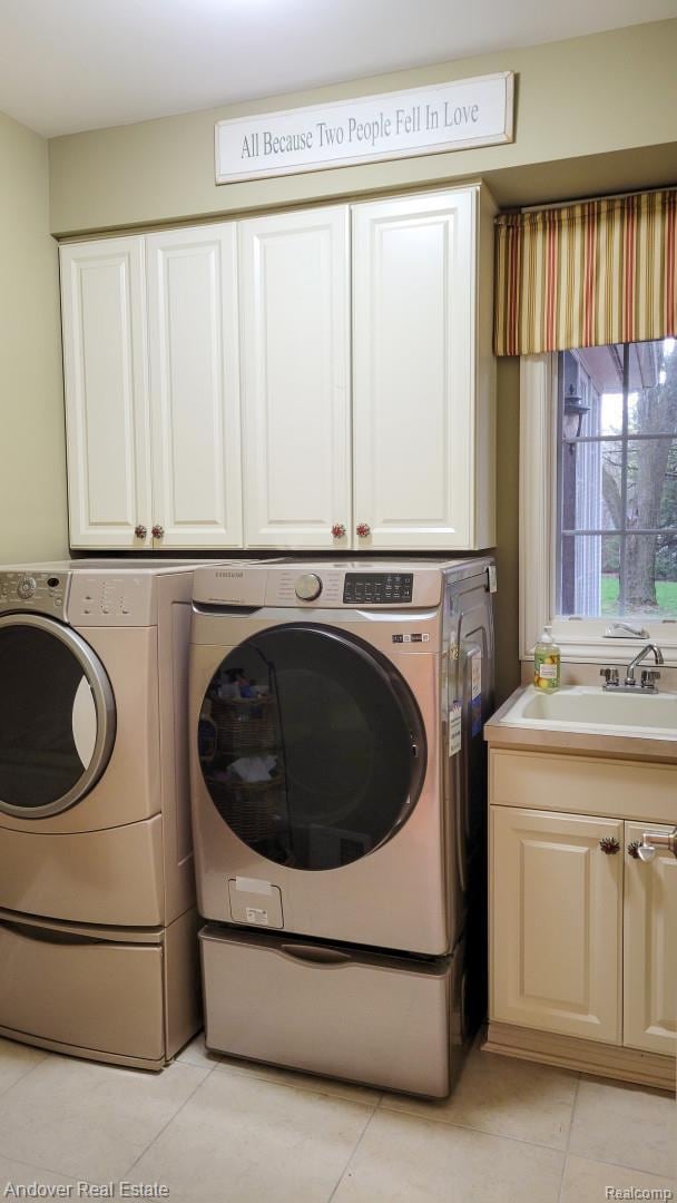 2004 Timberview Dr, Okemos, MI 48864 - washroom featuring washing machine and dryer, light tile patterned flooring, and cabinet space