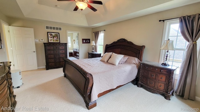 2004 Timberview Dr, Okemos, MI 48864 - bedroom featuring light carpet, a tray ceiling, connected bathroom, and ceiling fan