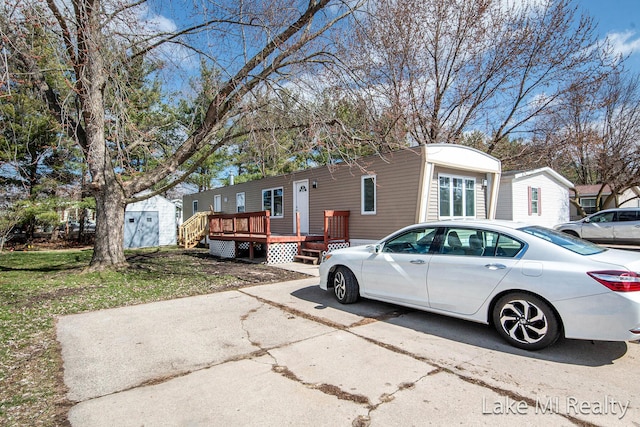 view of front of home with an outbuilding, a deck, and a storage shed