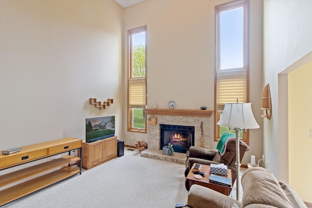 living room with carpet floors, a high ceiling, and a fireplace