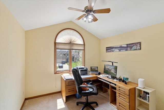 office area with baseboards, ceiling fan, light carpet, and vaulted ceiling