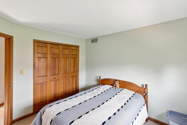 bedroom featuring visible vents, baseboards, light carpet, and a closet