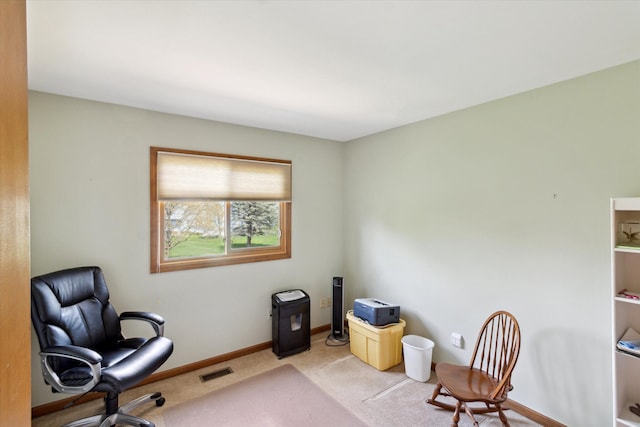 office with baseboards, visible vents, and light carpet