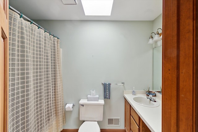 bathroom featuring a shower with curtain, visible vents, a skylight, vanity, and toilet