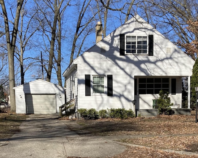 3309 Temple St, Muskegon, MI 49444 - view of front facade with driveway, a chimney, an outdoor structure, entry steps, and a garage