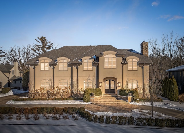 1044 Lakeside Dr, Birmingham, MI 48009 - french country style house featuring french doors, stucco siding, and a chimney