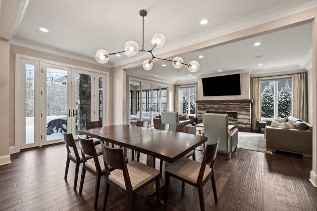 1044 Lakeside Dr, Birmingham, MI 48009 - dining space with a chandelier, a fireplace, french doors, crown molding, and dark wood-type flooring