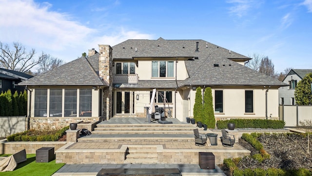 1044 Lakeside Dr, Birmingham, MI 48009 - back of property featuring a balcony, stucco siding, a chimney, a patio area, and a shingled roof