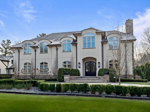 1044 Lakeside Dr, Birmingham, MI 48009 - view of front of house with french doors, stucco siding, and a chimney
