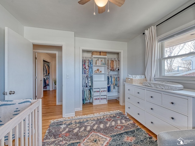 bedroom featuring baseboards, a closet, light wood-style floors, and a ceiling fan