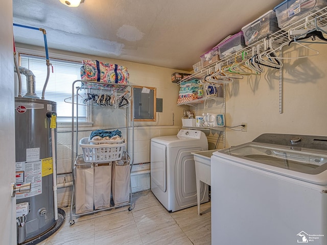 laundry area featuring electric panel, separate washer and dryer, a textured ceiling, gas water heater, and laundry area