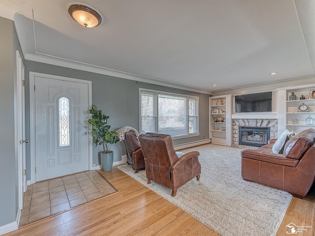 living room with a fireplace, crown molding, and wood finished floors