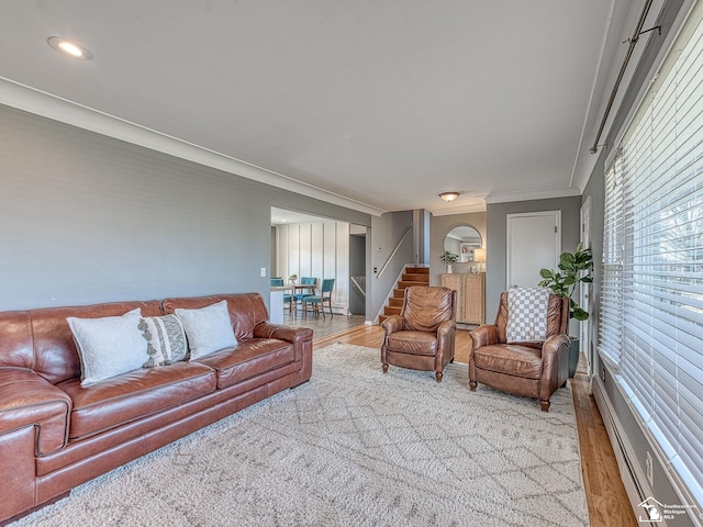 living area featuring crown molding, stairway, and wood finished floors