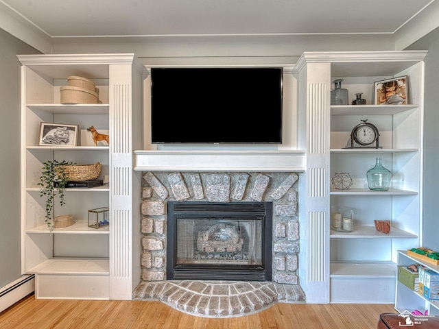 details featuring a stone fireplace, a baseboard heating unit, and wood finished floors