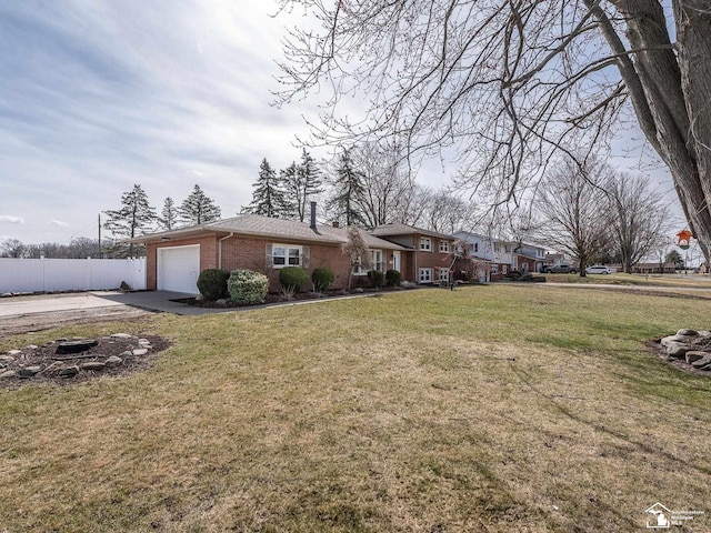 view of front of property with concrete driveway, fence, an attached garage, a front yard, and brick siding