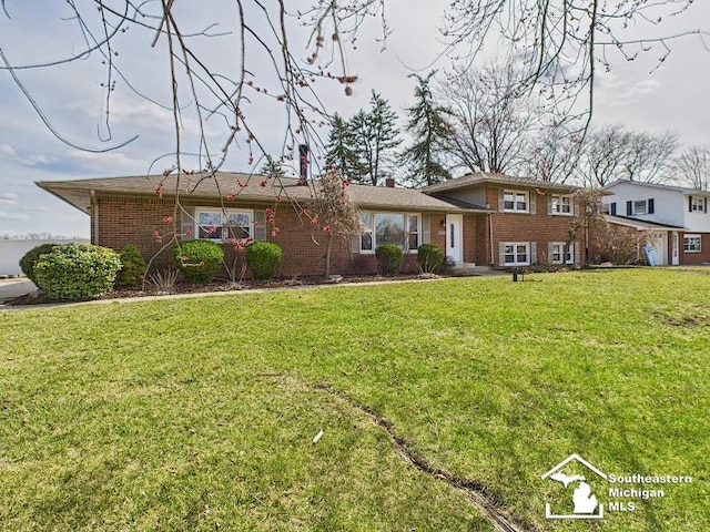 tri-level home with brick siding and a front yard