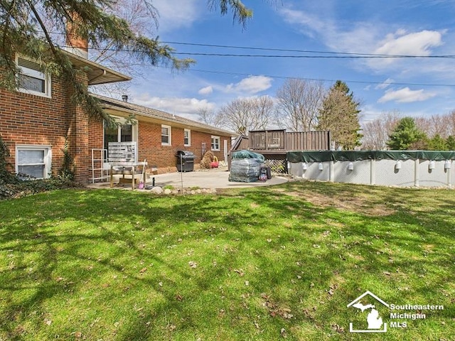 view of yard featuring a patio and a wooden deck
