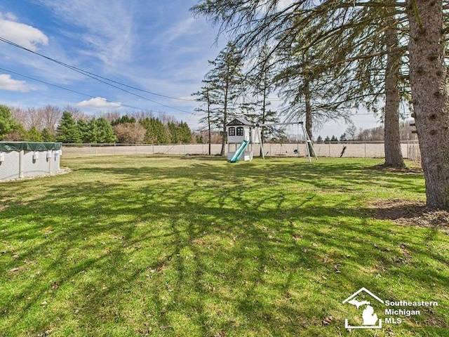 view of yard featuring a fenced backyard and a playground