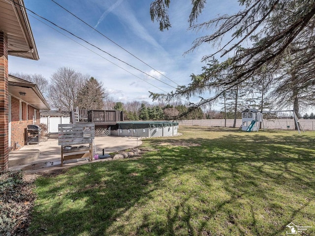 view of yard with a fenced backyard, a fenced in pool, a patio, and a playground